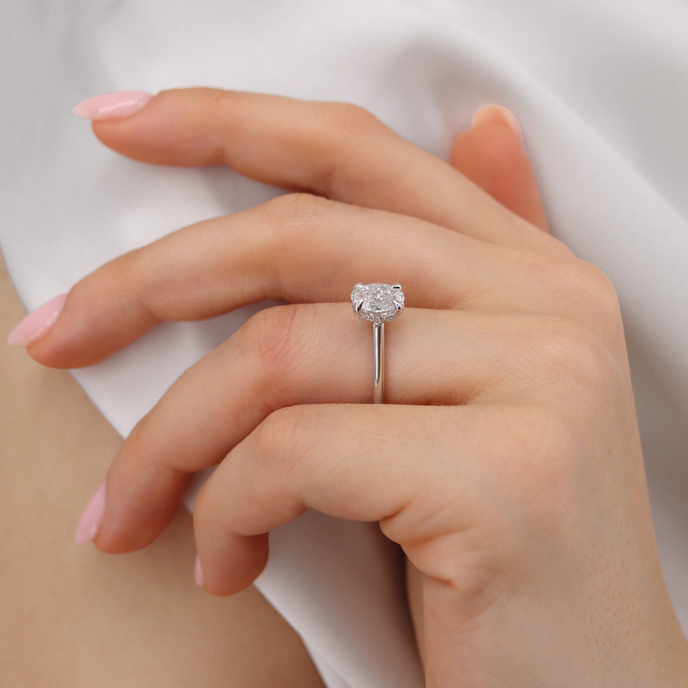 Model hand wearing the white gold solitaire ring with a relaxed pose.