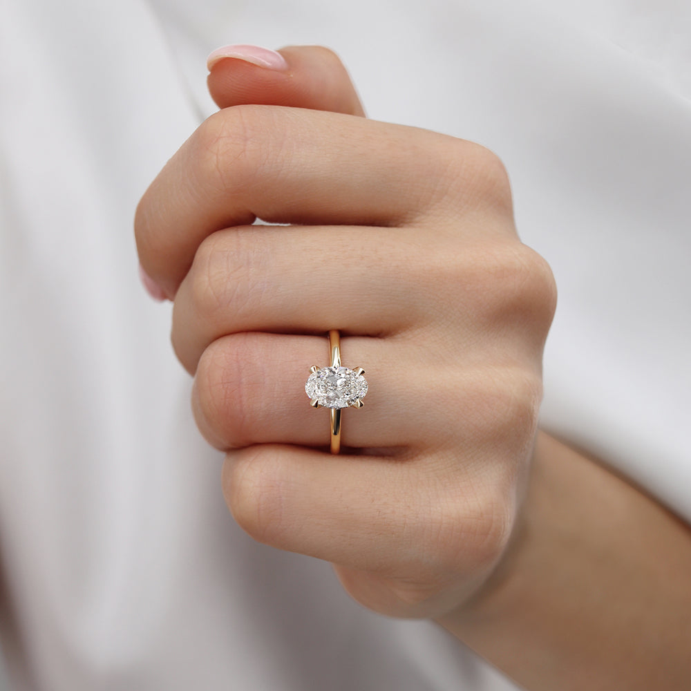 Model hand wearing the yellow gold solitaire ring in a subtle romantic gesture.