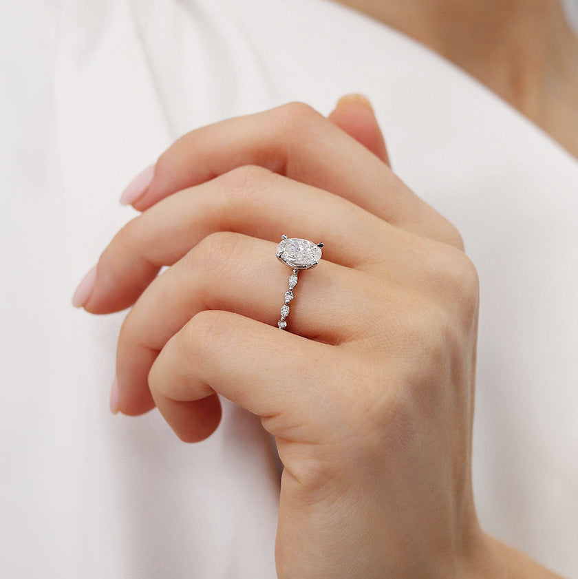 Close-up of ASTER oval cut lab diamond white gold scatter ring on model’s hand, lifestyle shot