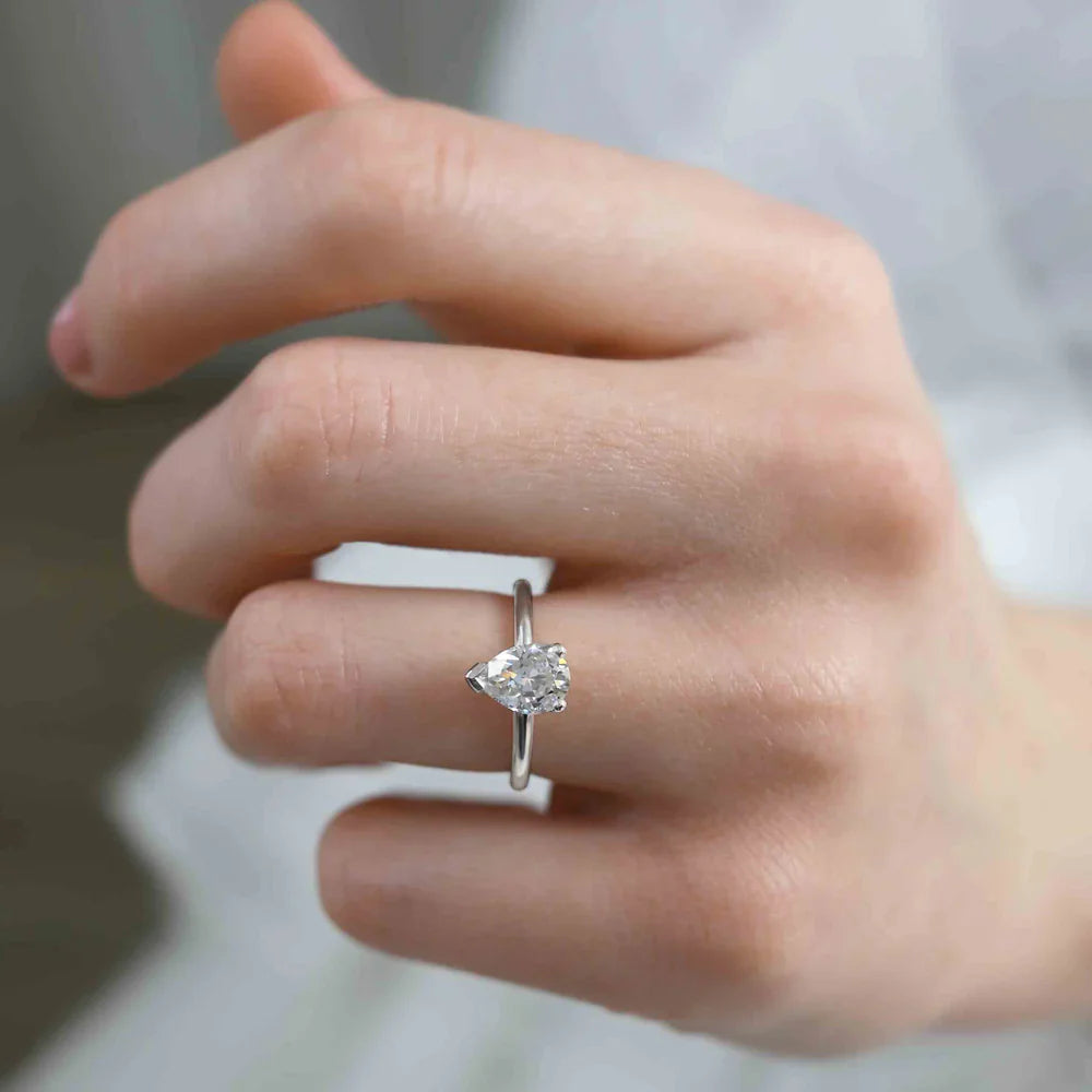 Pear shaped lab diamond solitaire engagement ring in platinum, lifestyle hand view