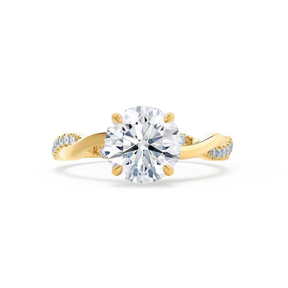 Front view of a round brilliant cut diamond engagement ring set in 18k yellow gold with a twisted pavé diamond band