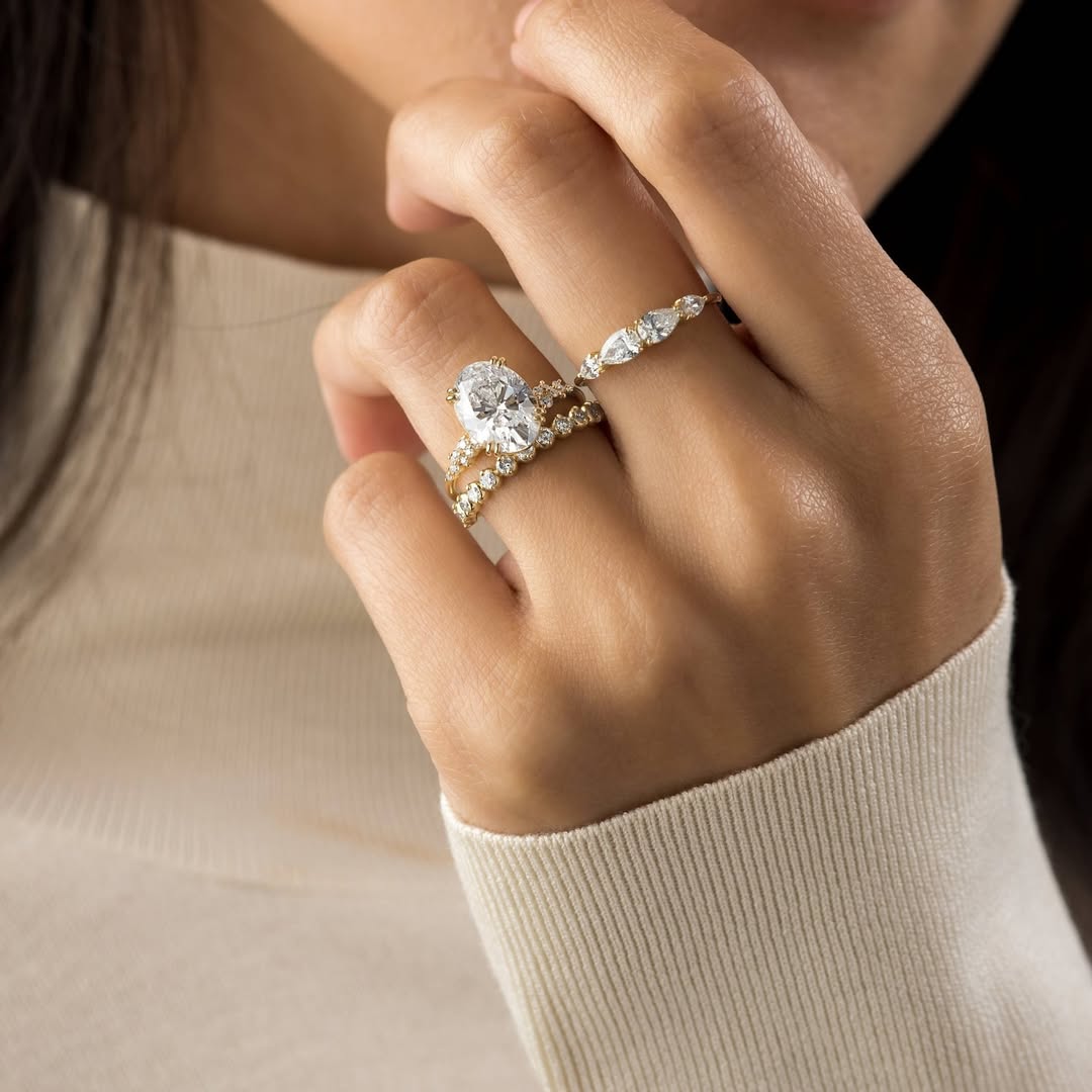 Elegant hands with double-stacked diamond eternity bands and a cushion halo ring.