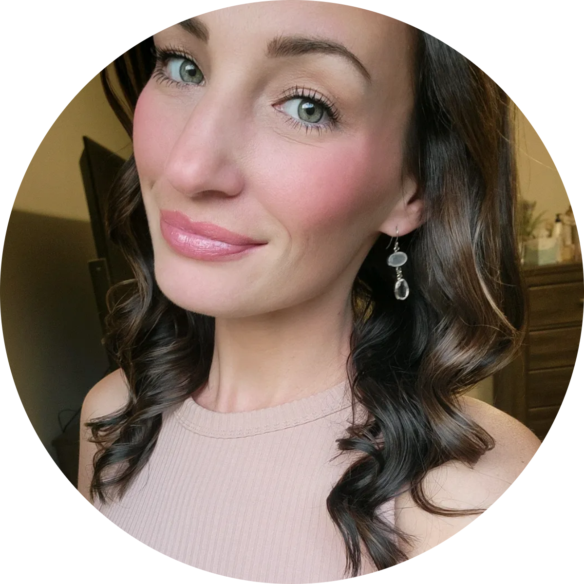 Elegant portrait of a woman with curled hair wearing earrings and a sleeveless beige top