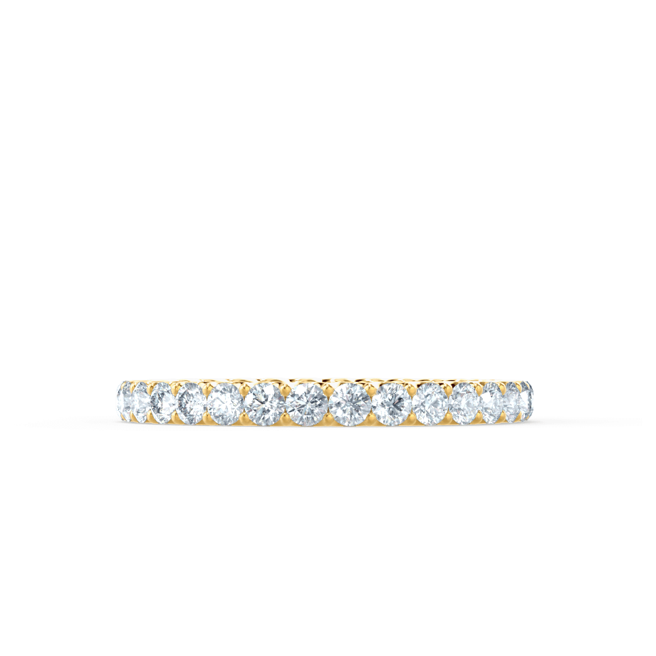 Side profile view of a delicate gold diamond band, highlighting fine craftsmanship and symmetry.