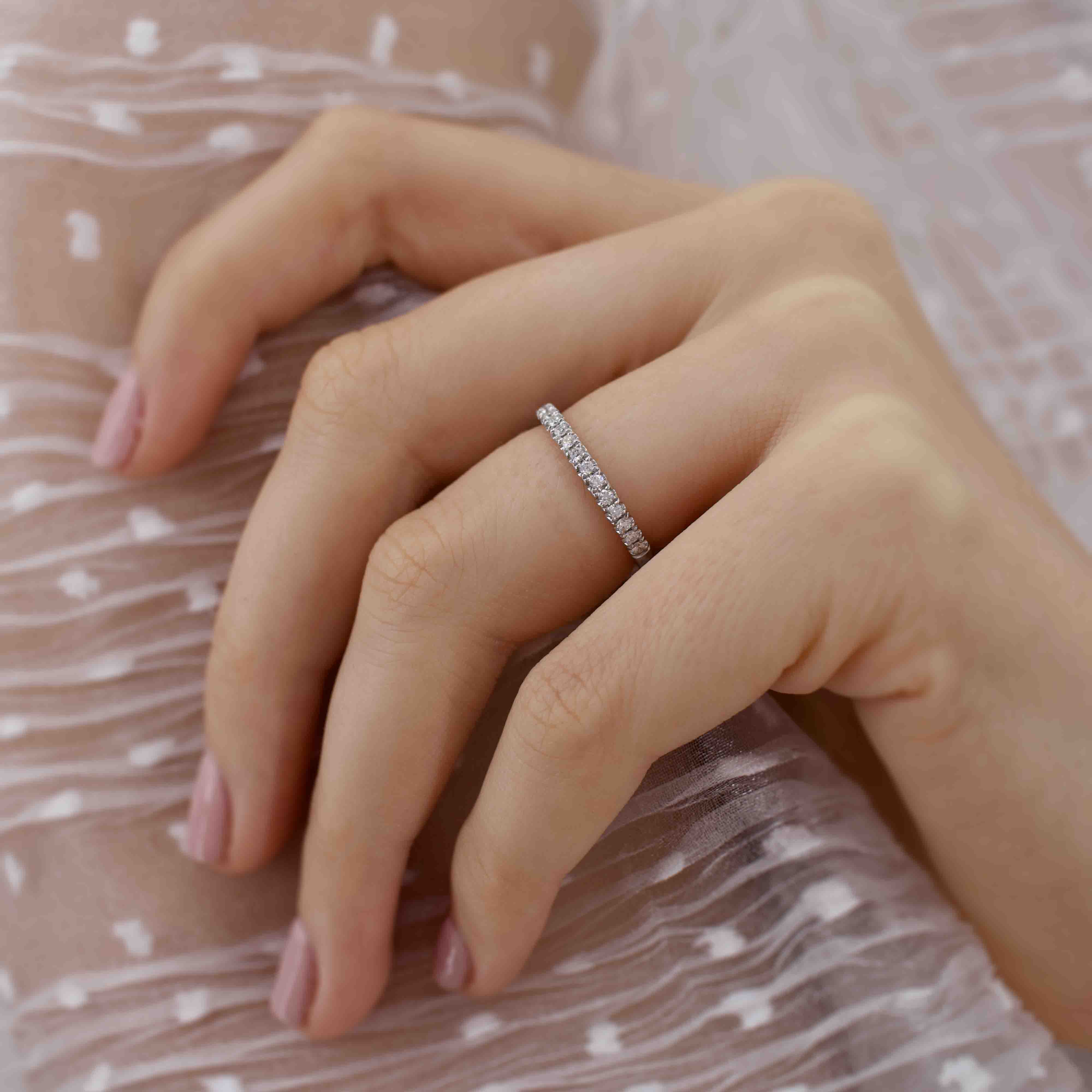 Model hand wearing the Luna band, resting on a blush pink textured fabric, showcasing subtle elegance.