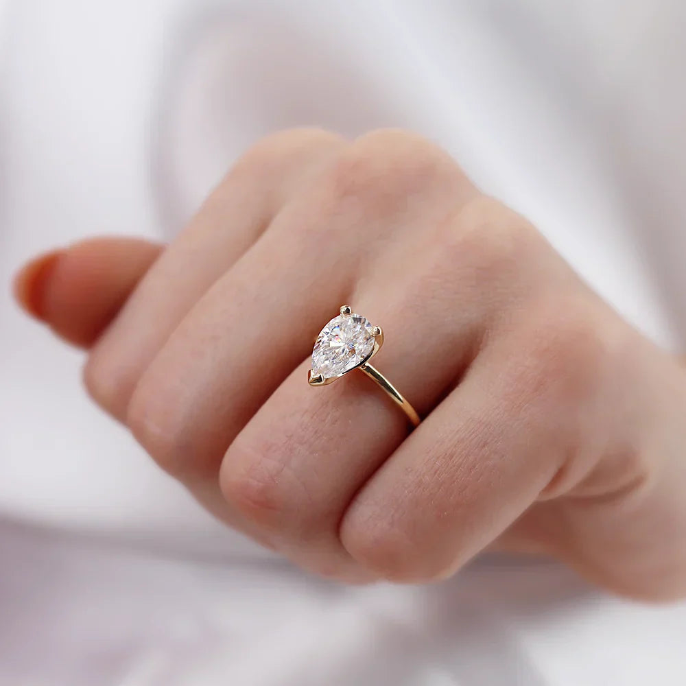 Pear shaped lab diamond solitaire engagement ring in 18k yellow gold, lifestyle hand view