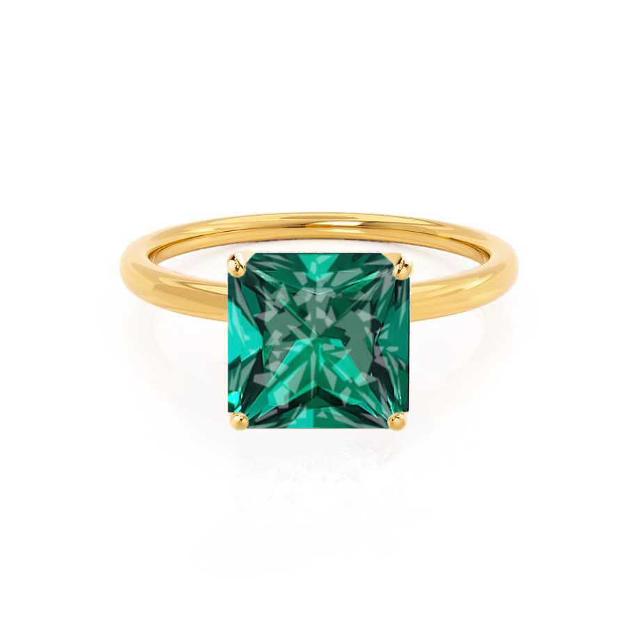 Front-facing view highlighting the brilliant green princess-cut emerald in warm yellow gold.