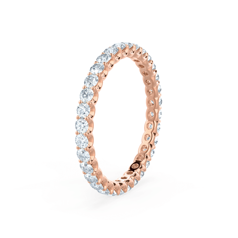 Full eternity band in rose gold, captured at a dynamic angle with diamonds all around.