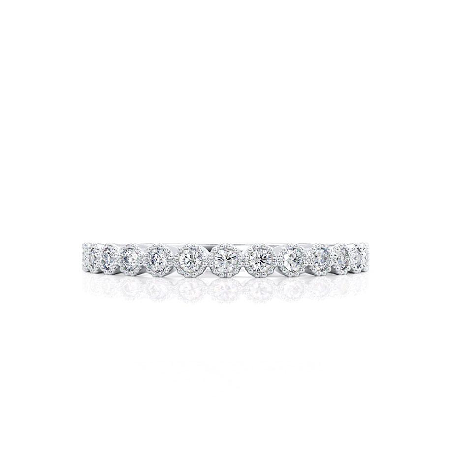Flat lay of white gold band with round prong-set diamonds, beautifully reflective design.
