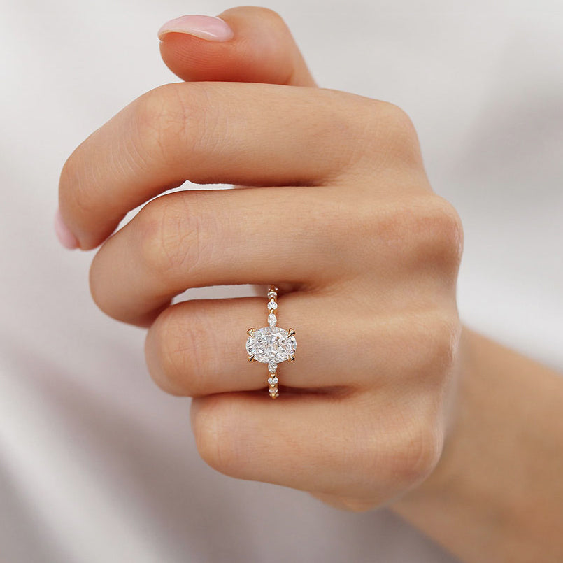 Woman wearing ASTER oval cut lab diamond engagement ring in 18k yellow gold, elegant hand view