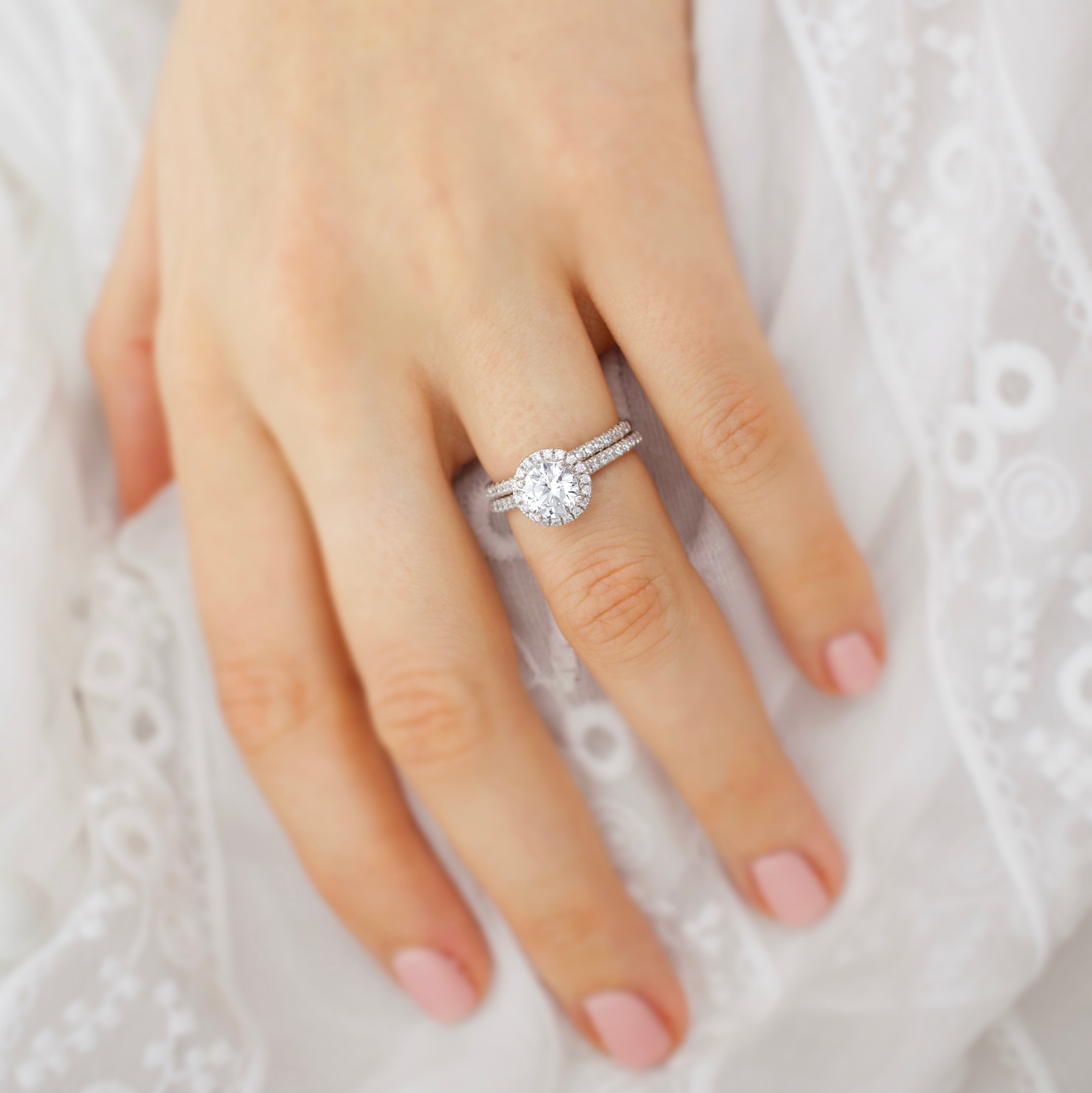 Lifestyle shot on hand, showcasing the petite halo's brilliance and feminine elegance in real-wear context.