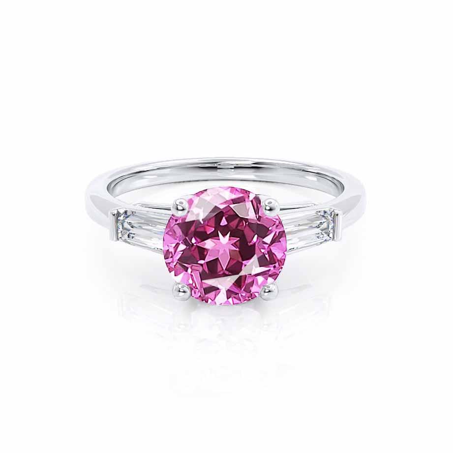 Front view showcasing the round lab-grown pink sapphire flanked by two baguette-cut diamonds on a polished platinum band.