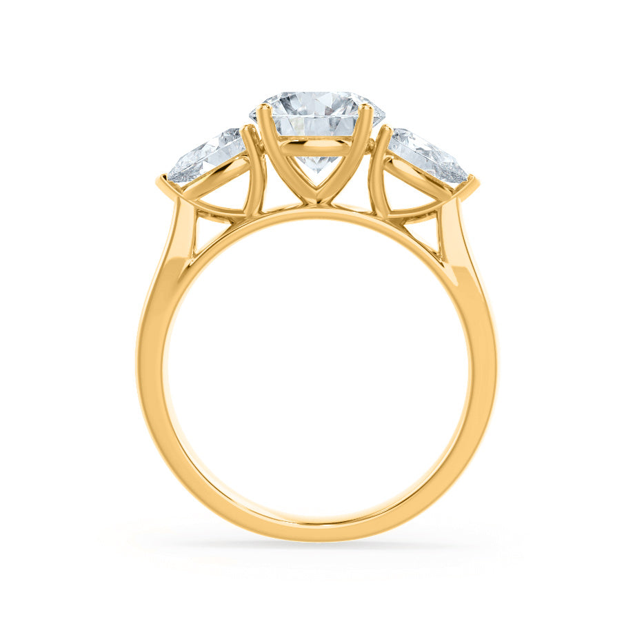 Side view of oval lab diamond trilogy ring in 18k yellow gold with pear cut side diamonds