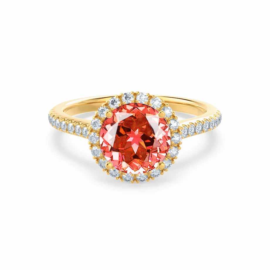 Front view of the vibrant Padparadscha sapphire encircled by a diamond halo, glowing warmly in 18k yellow gold.