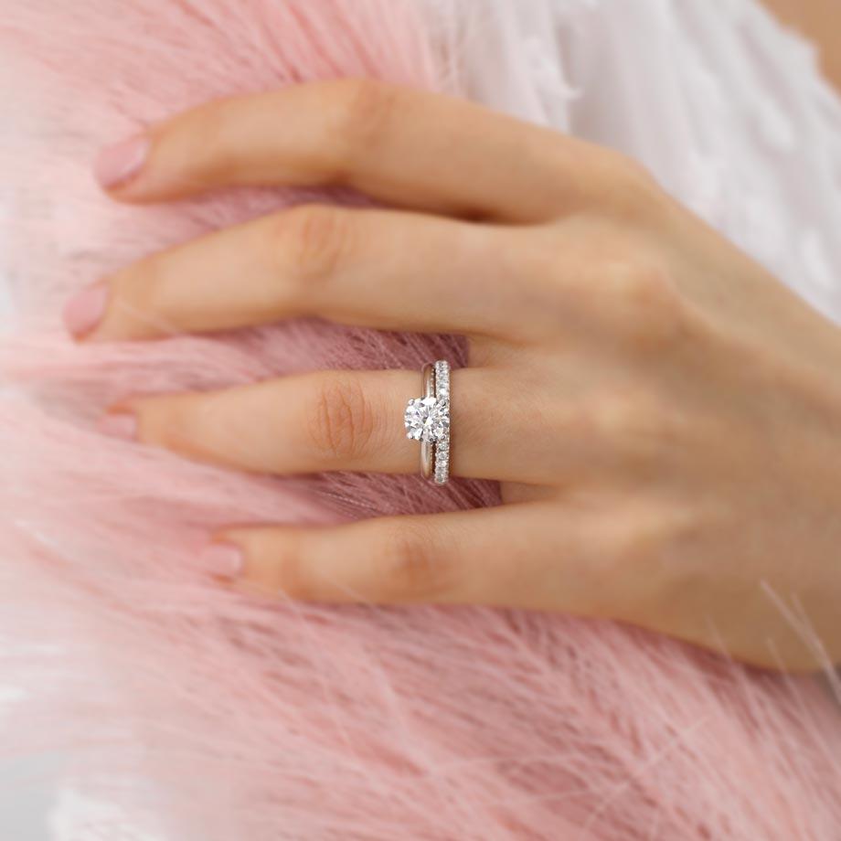 Close-up of the LUNA band worn on hand, showcasing its slender silhouette and shimmering pavé diamonds against soft pink tones.