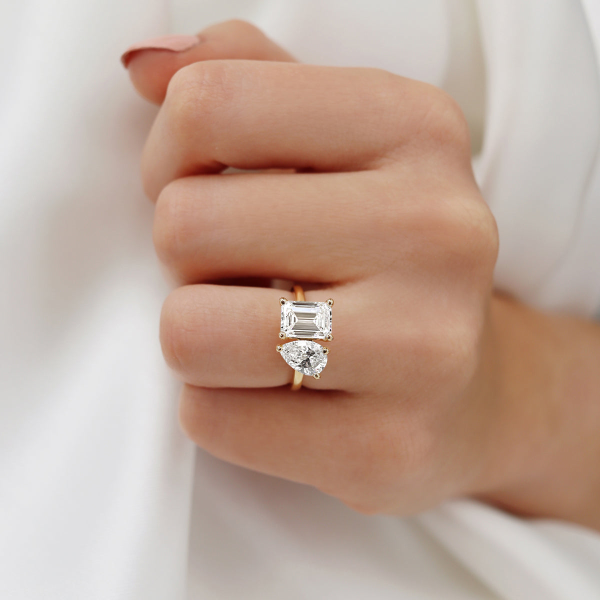 Front view of the emerald cut twin diamond ring worn on hand