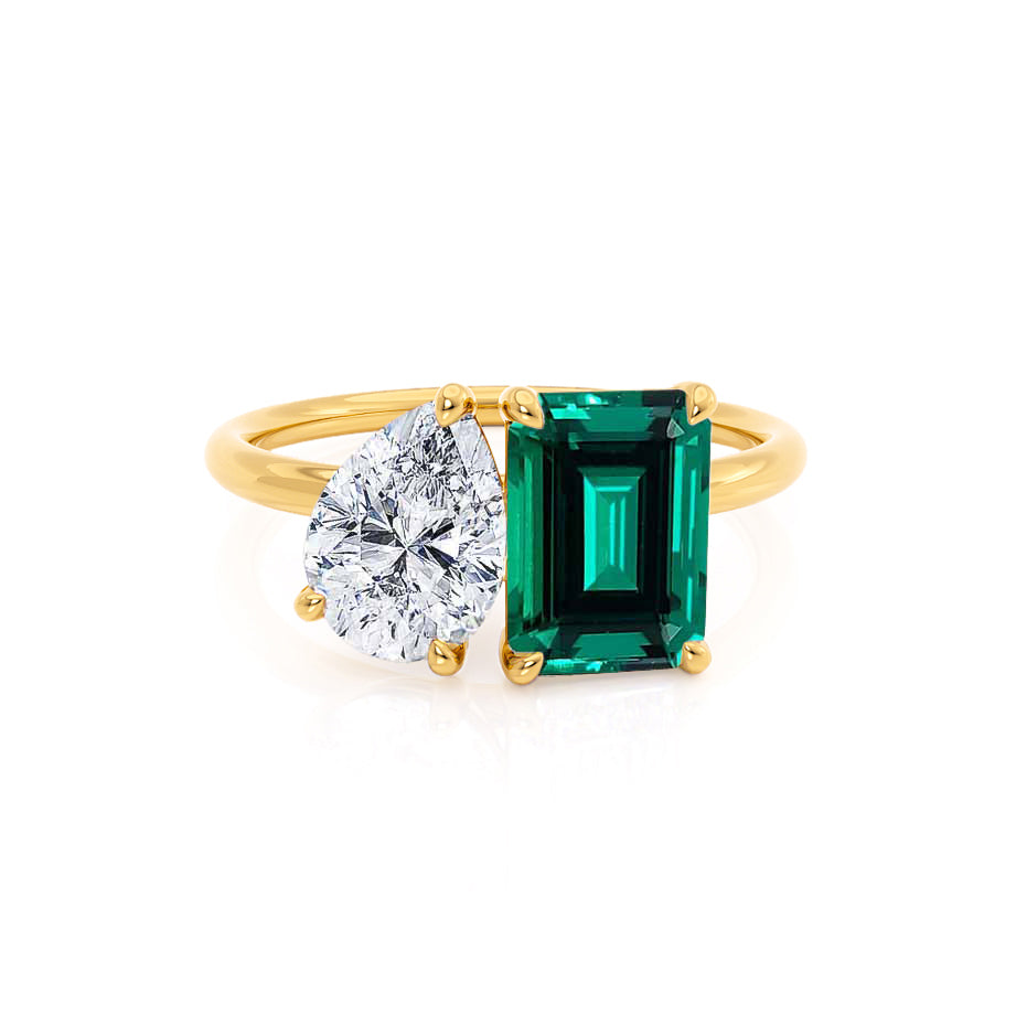 Front view – A golden harmony of dual stones: emerald-cut green emerald and pear-cut diamond set in 18k yellow gold.