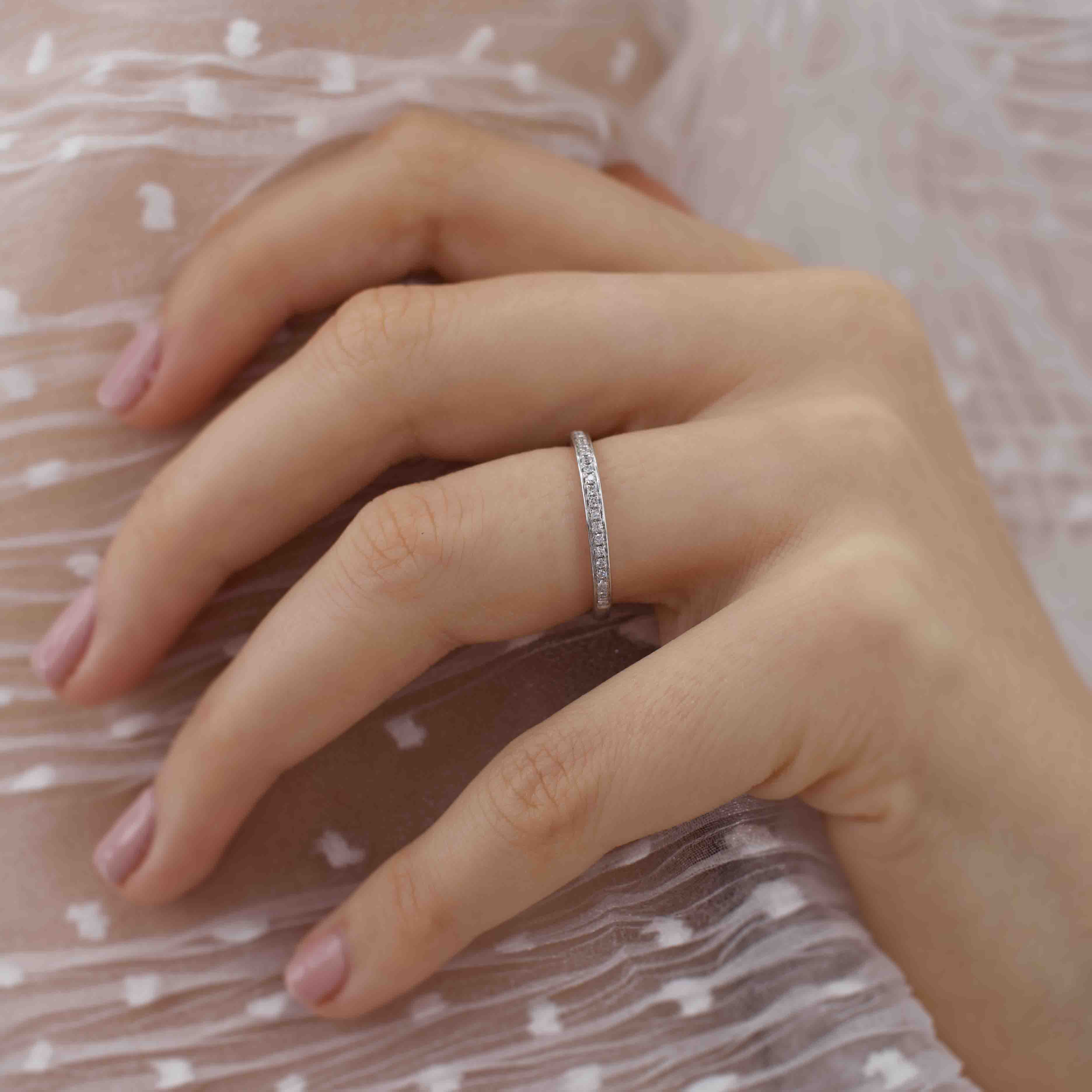 Close-up of model wearing a thin white gold pavé diamond ring, elegant daily wear style.