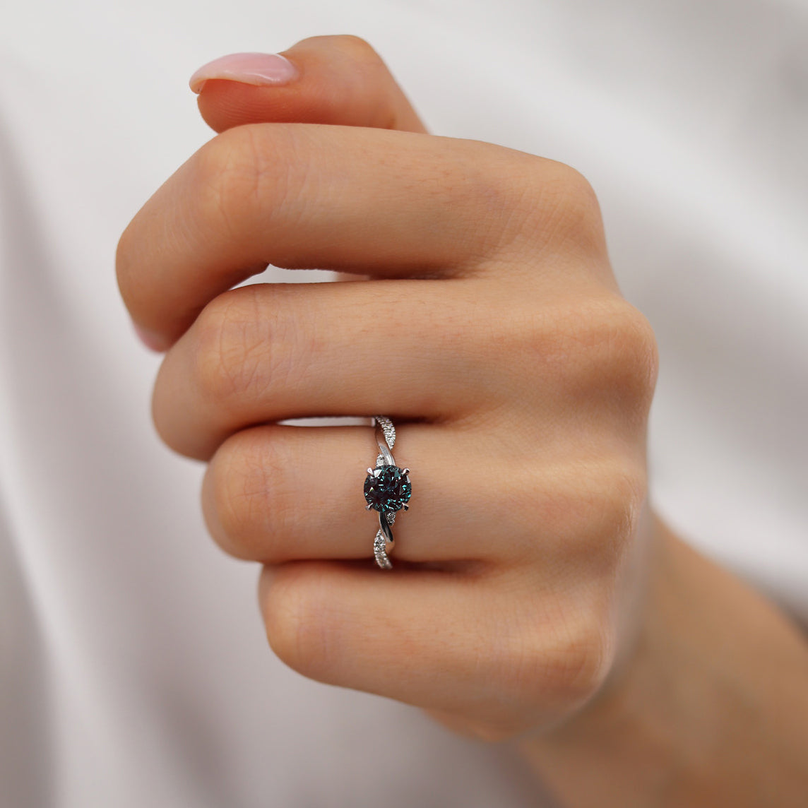On-hand image capturing the elegant contrast between the violet Alexandrite and the shimmering pavé diamond vine.